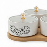 4 - Piece White Ceramic Candy Bowl Set with Black Elegant Design, Matching Lids & Bamboo Base – Premium Serving Set (21×21 cm) - Al Kabayel Discount Centre4 - Piece White Ceramic Candy Bowl Set with Black Elegant Design, Matching Lids & Bamboo Base – Premium Serving Set (21×21 cm)Jars & Food SaversAKDCAl Kabayel Discount Centre