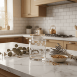 Almarjan Cylindrical Glass Candy Pot | Gold - Rimmed Botanical Elegance | 17×10cm - Al Kabayel Discount CentreAlmarjan Cylindrical Glass Candy Pot | Gold - Rimmed Botanical Elegance | 17×10cmJars & Food SaversALMARJANAl Kabayel Discount Centre