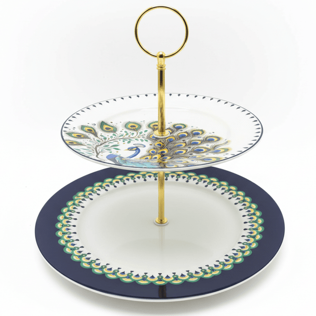  "Elegant two-tiered peacock serving stand with navy blue and white porcelain plates and gold metal stand on white background"